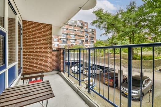 A scenic view from a modern apartment balcony, showcasing a vibrant landscape with trees and parked cars, creating a serene urban ambiance.