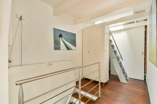 A contemporary indoor staircase featuring sleek railings and a striking wall painting, blending functionality with aesthetic appeal in a bright setting.