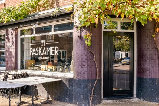 A quaint cafe exterior featuring outdoor seating amidst lush greenery. The rustic architecture and inviting atmosphere attract passersby for a relaxing cafe experience.