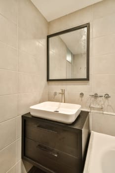 A sleek and contemporary bathroom featuring stylish fixtures and a minimalist design. The space includes a mirror and a convenient sink area for everyday use.