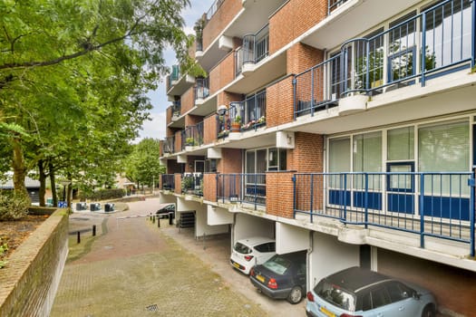 A view of a contemporary multi-story apartment building featuring multiple balconies and landscaped greenery, showcasing urban living and architecture.