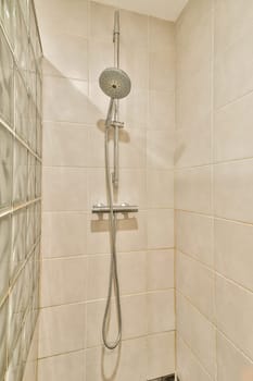 A sleek shower fixture mounted on a light-colored tiled wall, offering a contemporary look and feel to the bathroom space.
