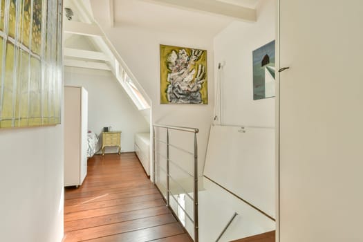 A spacious modern interior featuring wooden flooring, white walls, and artistic wall decor that creates an inviting and stylish ambiance.