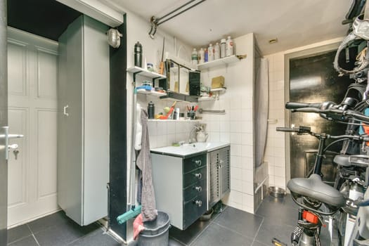 A contemporary utility room featuring shelving, a sink, and bicycles parked beside. The interior combines functionality with sleek design elements.