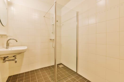 Sinks with mirrors and shower box with glass door in modern bathroom with white tiled walls