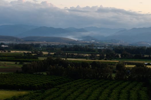 Golden light filters through the clouds as evening descends upon the valley.
