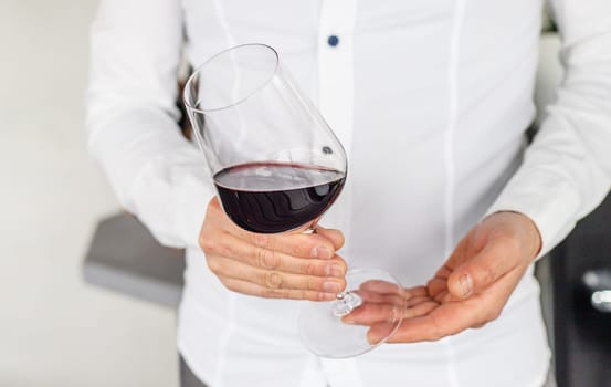 Glass of red wine in hands. Selective focus. drink.