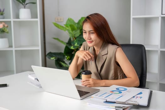 In her workspace, the woman beams while reviewing her performance metrics, demonstrating a positive attitude towards her tasks.