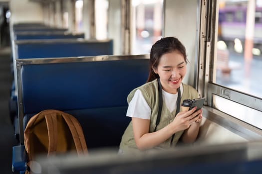 A cheerful traveler engaged with her smartphone as she relaxes in her train seat, combining modern communication with the joys of travel.