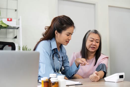 A healthcare professional engages in a conversation with a senior patient, discussing health metrics and empowering them with knowledge about their well-being.
