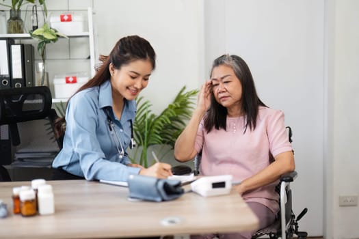 In a supportive clinic setup, a nurse engages with a senior woman, documenting vital health information while ensuring patient comfort and ease.