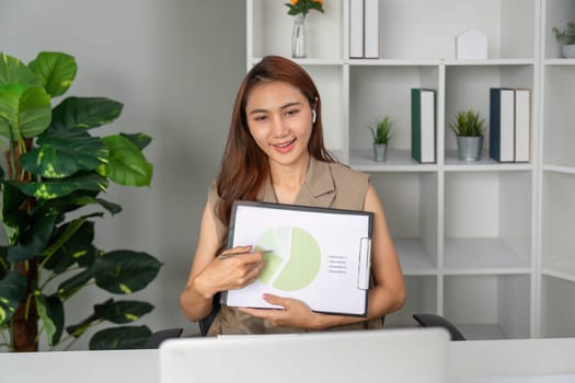 A businesswoman explains statistics using a pie chart during a video call, showcasing professional communication skills and teamwork in action.
