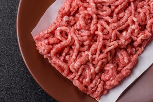 Stuffing or ground raw beef or pork with salt and spices on a black background