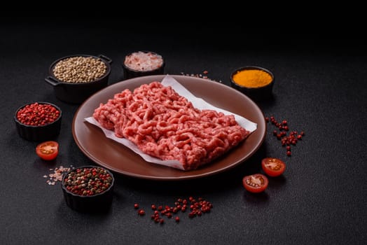 Stuffing or ground raw beef or pork with salt and spices on a black background