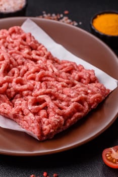 Stuffing or ground raw beef or pork with salt and spices on a black background
