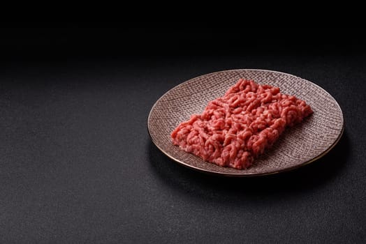 Stuffing or ground raw beef or pork with salt and spices on a black background