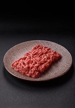 Stuffing or ground raw beef or pork with salt and spices on a black background