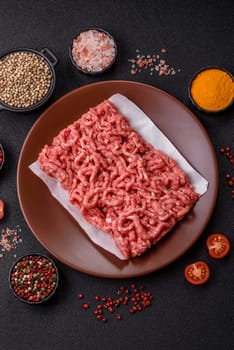 Stuffing or ground raw beef or pork with salt and spices on a black background