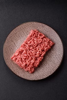 Stuffing or ground raw beef or pork with salt and spices on a black background