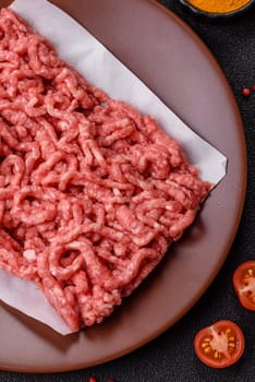 Stuffing or ground raw beef or pork with salt and spices on a black background