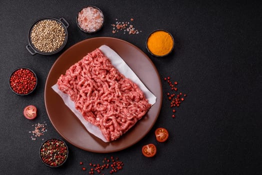 Stuffing or ground raw beef or pork with salt and spices on a black background