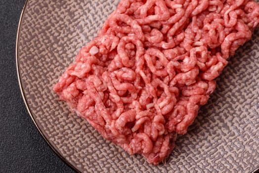 Stuffing or ground raw beef or pork with salt and spices on a black background