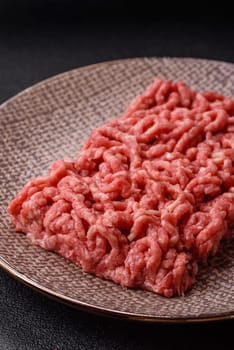 Stuffing or ground raw beef or pork with salt and spices on a black background