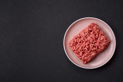 Stuffing or ground raw beef or pork with salt and spices on a black background