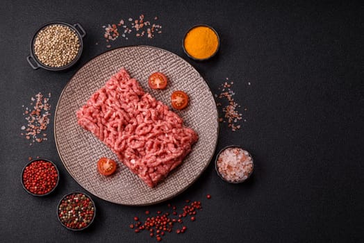 Stuffing or ground raw beef or pork with salt and spices on a black background