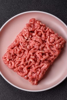 Stuffing or ground raw beef or pork with salt and spices on a black background