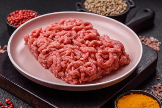 Stuffing or ground raw beef or pork with salt and spices on a black background