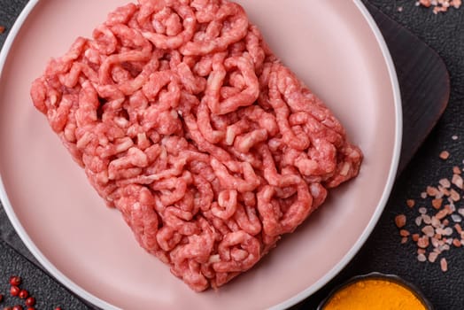 Stuffing or ground raw beef or pork with salt and spices on a black background