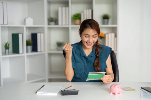 The woman shows excitement as she reviews a successful financial statement, celebrating savings and achieving her budgeting goals.