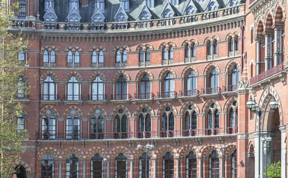 London, UK - Apr 11, 2025 - Stunning exterior of the gothic building where the St. Pancras Renaissance Hotel (The Midland Grand Hotel) with typical balconies and glass windows in victorian architecture. use it as your Wallpaper, Poster and Space for text, Selective focus.