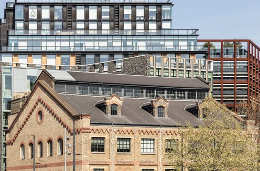 London, UK - Apr 11, 2025 - Exterior view of The German Gymnasium and One Pancras Square with with Skyscrapers background in the City of London. Architectural of Historic Building and New building in Contrasting Classical and Modern. use it as your Wallpaper, Poster and Space for text, Selective focus.