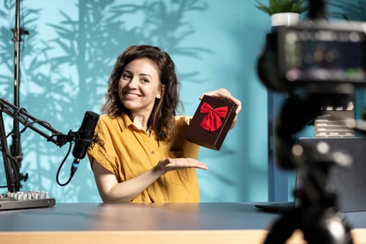 Vlogger holding giveaway for viewers, offering gift box, engaging with audience to drive engagement and increase participation. Content creator organizing contest, explaining rules and prize details