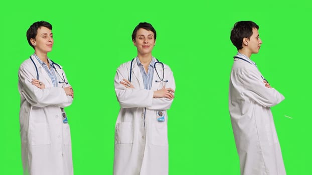 Portrait of successful physician standing with arms crossed against greenscreen backdrop, wearing a white coat and stethoscope. Doctor feeling confident with healthcare expertise. Camera B.