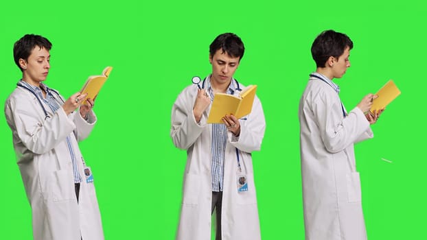 Medic specialist reading a healthcare literature book to develop her medical expertise in the industry, stands against greenscreen backdrop. Clever doctor in white coat enjoys lecture. Camera B.