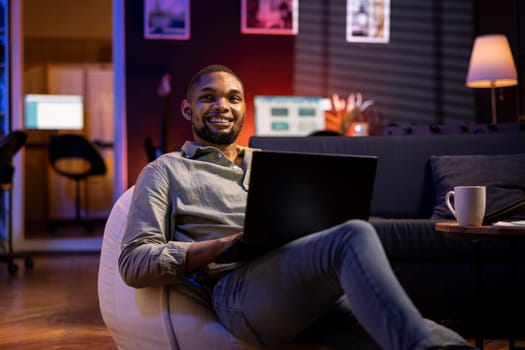 Male analyst examining monthly budget and expenses to provide strategic advice on products and services. Black young business expert analyzing revenue balance, accounting at home.