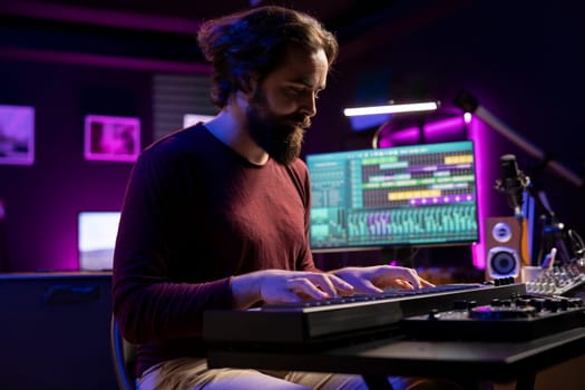Skilled artist creating new music on electronic midi controller in home studio, recording songs with mixing console and daw software. Singer playing piano keyboard notes, synthesizer tool.
