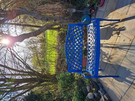 blaue Bank aus Gusseisen auf einer kleinen Terrasse