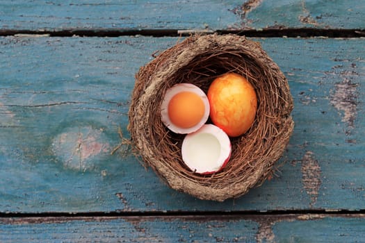 An Easter nest with colorful hard-boiled eggs on a wooden base
