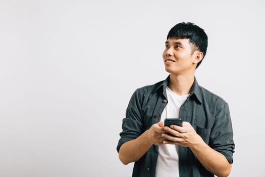 Portrait Asian smiling young man holding mobile phone on hand studio shot isolated white background, Happy excited lifestyle businessman using smartphone browsing internet, happiness and enjoyment
