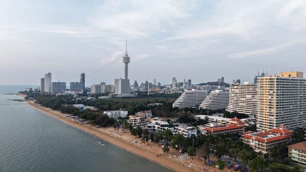 Aerial view of pattaya beach during sunset, showcasing the coastline with hotels, resorts, and the iconic pattaya park tower dominating the skyline
