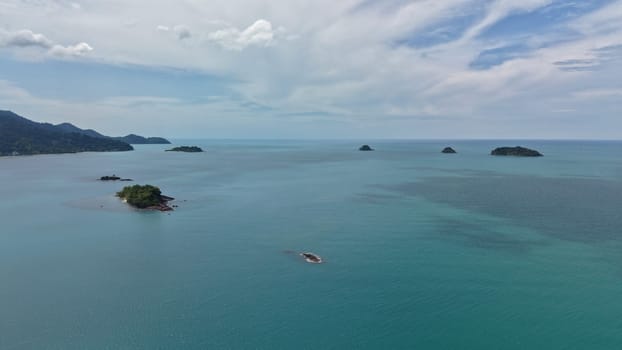 Breathtaking aerial view of lush tropical islands dotting the turquoise waters under a cloudy sky, creating a serene and idyllic island paradise scene