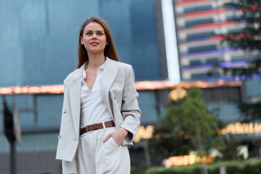 confident woman in beige business suit outdoors, smiling with modern cityscape background, professional style, positive mood, business concept for corporate success