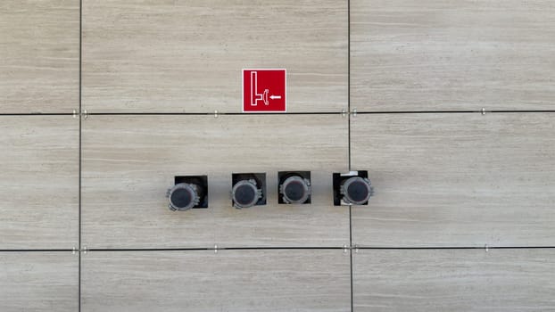 System of dry riser with pipe outlets to street to ensure safety in building. Pipe for connecting fire engine hose when extinguishing fire. Sign indicating of hydrant connection in case of fire