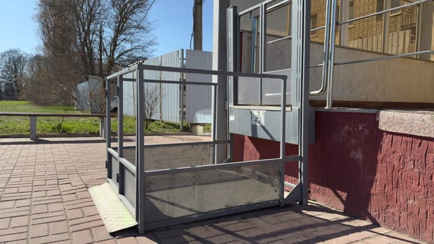 Safe elevator for wheelchair users. Outdoor elevator for access to building for people with disabilities. Accessible environment device for people with disabilities. Caring for people in modern city