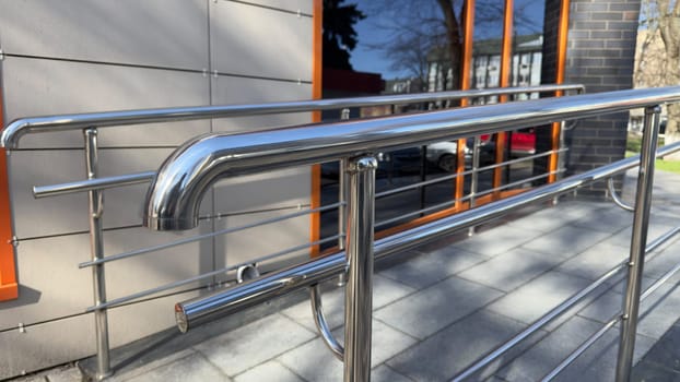 Handrails for grabbing when climbing ramp for people with disabilities. Creating comfortable entrance with care for people with mobility problems. Ramp for strollers and wheelchairs