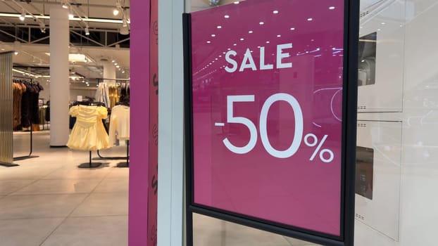 Big sale in clothing store. Prices in store are halved. Luring customers with big discount. Sale 50 percent in clothing and accessories shop. Marketing and attracting new customers with discounts